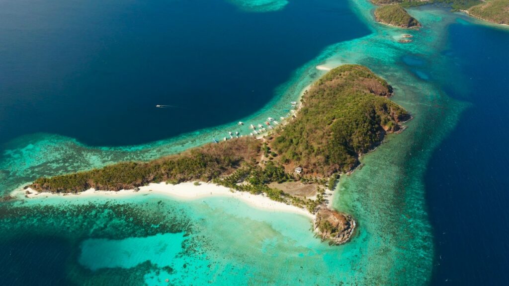 View of Malcapuya Island featuring a pristine white sand beach near Coron Palawan Philippines.