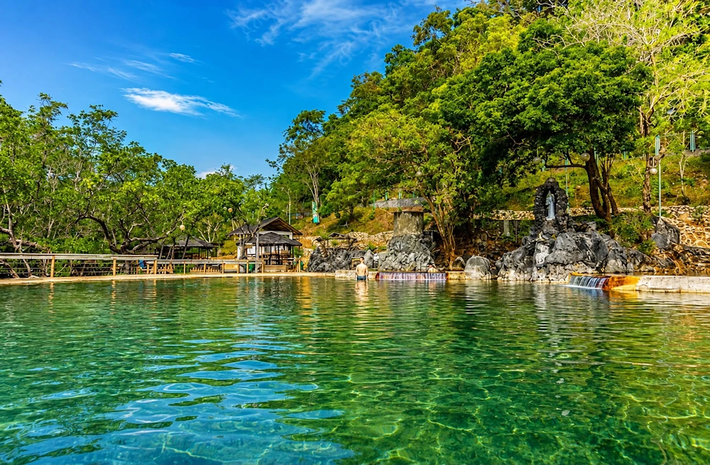 A visitor soaking in the natural saltwater pool at Maquinit Hot Spring, Coron, Palawan