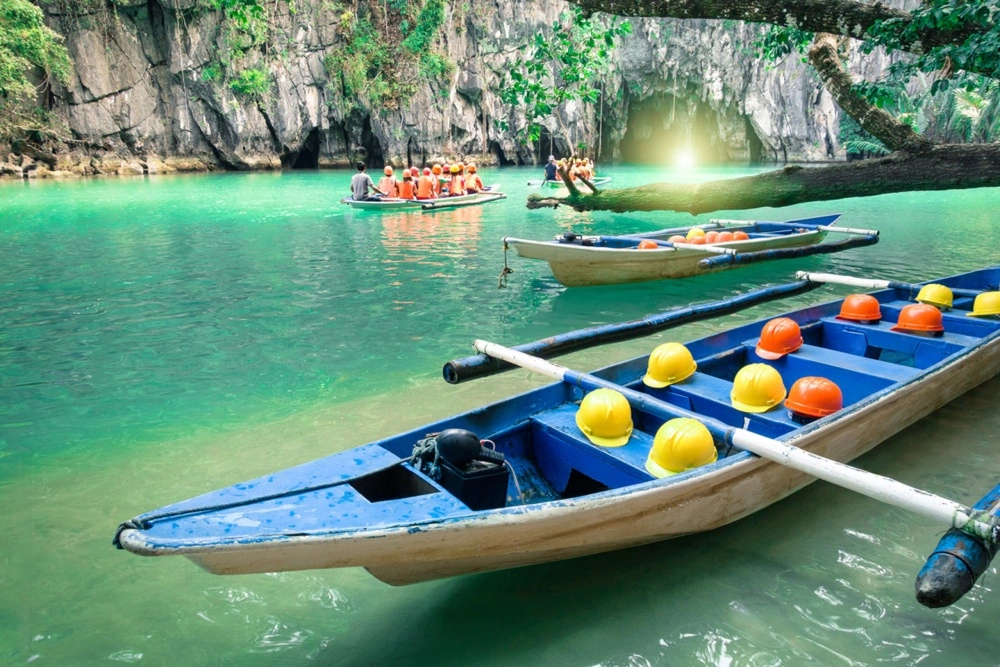Paddle boats carrying tourists near the cave entrance of the Underground River, a top thing on what to do in Puerto Princesa Palawan.